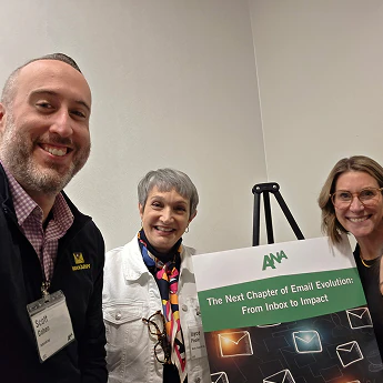 InboxArmy team member with two attendees beside an ANA email event sign