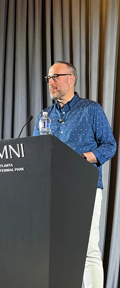 Speaker presenting from a podium at a conference